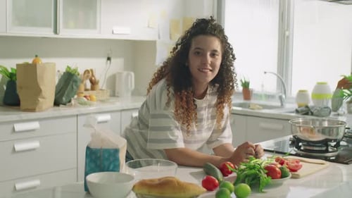 Woman Smiling in Bright Home Kitchen with Produce