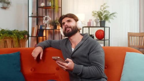 Man with headphones relaxing on couch listening music