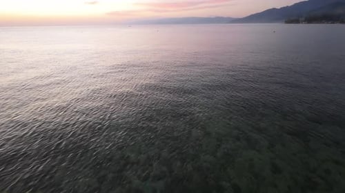Calm Sea at Sunset with Distant Shoreline