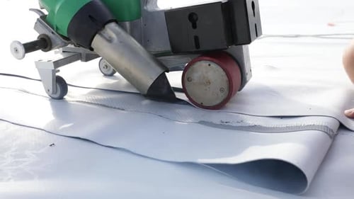 Machine Sealing White Roofing Material Together