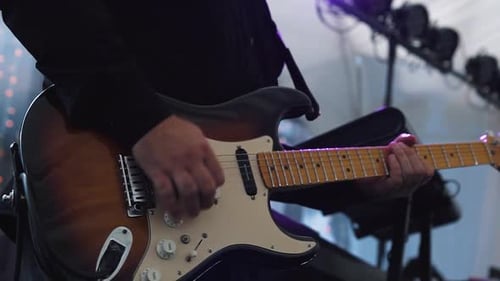 Close-up of Guitar Player Strumming Electric Guitar on Stage