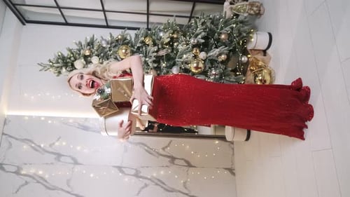 Woman in Red Dress Holding Christmas Gifts