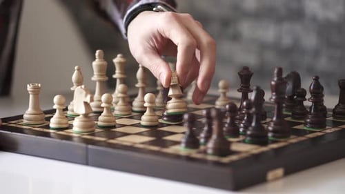 Hand Moves Chess Piece on Chessboard Close Up
