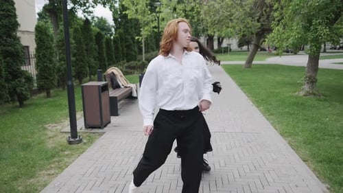 A Couple Dances Joyfully in a Park Showcasing Spontaneity and Connection