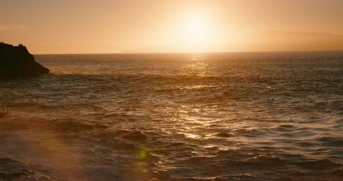 Dramatic Sunset Light Reflected on Ocean Waves at Rocky Coastlinet Golden Hour Light in Slowmotion