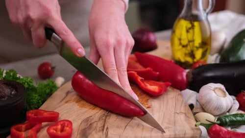 Hands Cutting Red Bell Pepper on Cutting Board