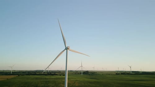 Aerial Wide Drone View of a Wind Farm Park with Wind Turbines Standing in a Wheat Field at Sunset