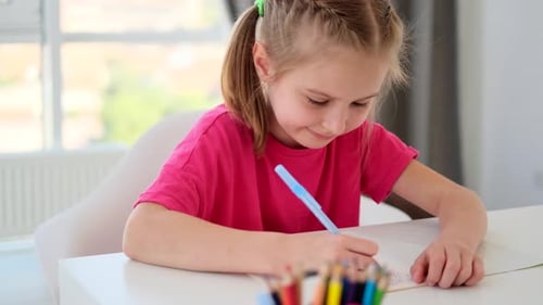 School Girl Writing in Notebook During Lesson