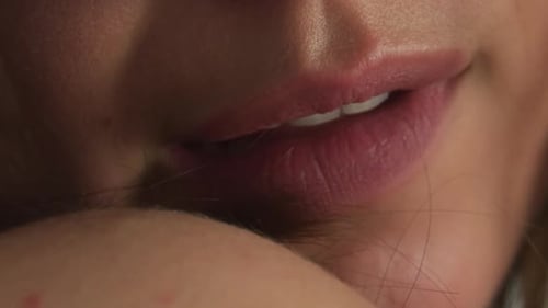 Young Caucasian female biting on her lip, close-up footage