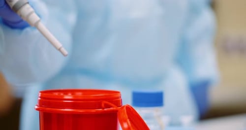 Laboratory Work with Pipette and Red Container