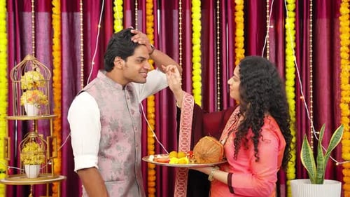 Woman Applies Mark to Man's Forehead in Ceremony