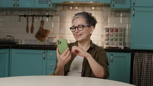 Mature Woman Showing Vertical Green Screen Cellphone at Camera and Giving Thumbs Up