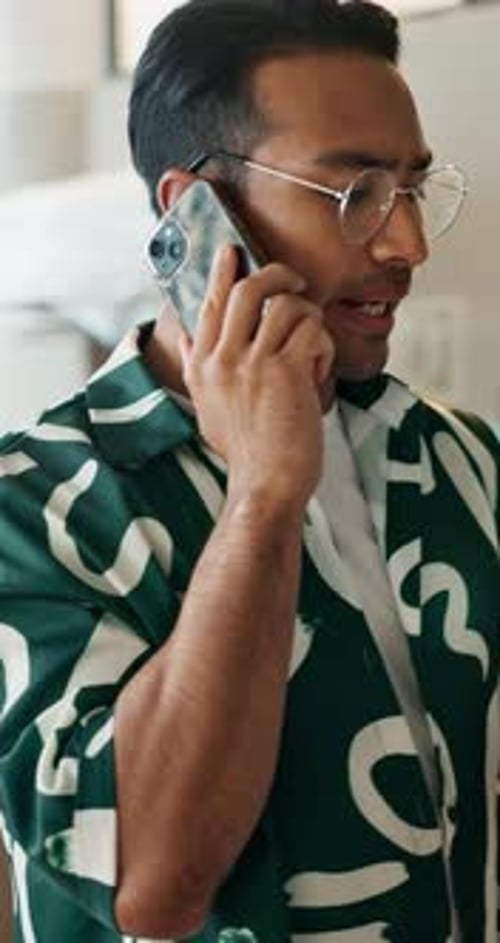 Man Talking on Phone While Holding Tablet