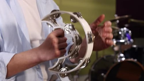 Man playing tambourine in studio, closeup view