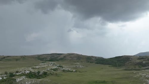 Luftaufnahme von Wiesen, die an einem bewölkten Tag auf dem Land mit weichem Nebel bedeckt sind