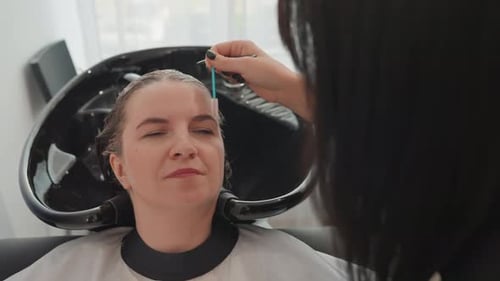 Woman Receiving Eyebrow Treatment at Hair Salon