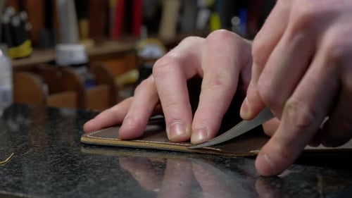 Craftsman Trimming Leather Edge in Workshop