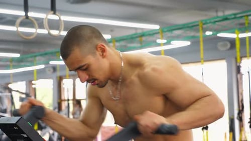 Man Working Out on Exercise Machine at the Gym