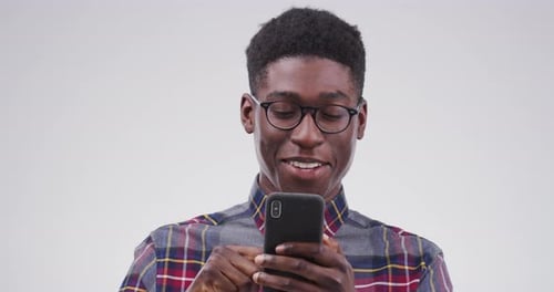 Young Man Using Smartphone and Smiling