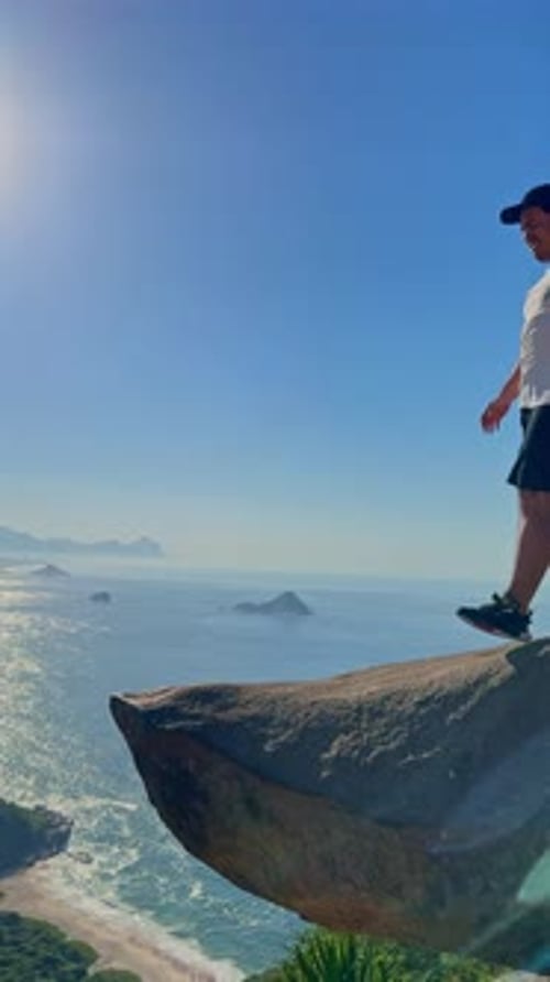 Wide shot of a male rock climber descending down a rock face
