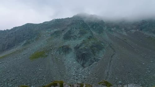 Flying to the summit of a misty mountain with amazing blue rocks