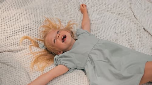 portrait of a happy girl lying on a blanket in the park Dreamy face of a child a child looks