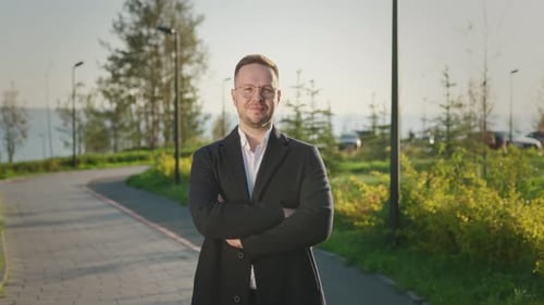 Confident Man Smiling With Arms Crossed Outdoors