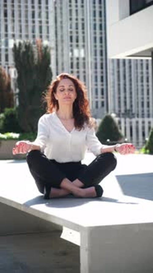 Businesswoman meditating outdoors in the city
