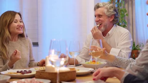 Friends Enjoying Dinner and Wine Together at Home