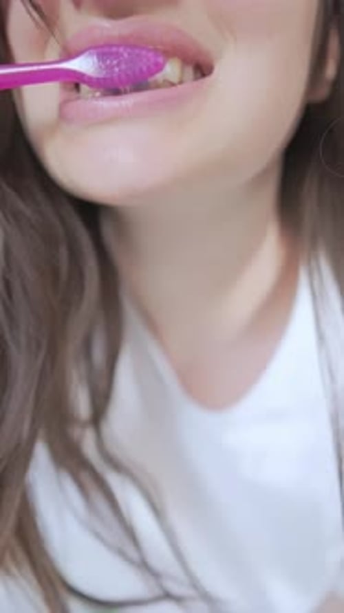 Young Adult Woman Brushing Teeth Close Up