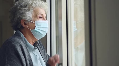 Depressed Senior Woman with Face Mask Stay at Home During Covid-19 Pandemic
