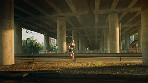 Beautiful Fitness Girl in Black Athletic Top and Shorts is Energetically Running in the Street. She