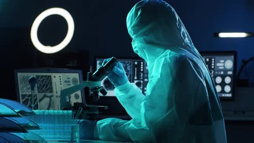 Researcher using Microscope in Dark Lab