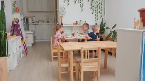 Children Eating Meal Together in Bright, Playful Room