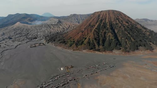 Aerial view of volcanic eruption and jeeps, Indonesia.
