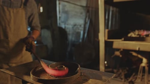 Blacksmith Forming Red Hot Metal Piece in Workshop