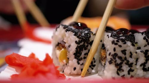 Chopsticks Taking Sushi in a Japanese Restaurant