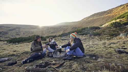 Friends Gather by Campfire in a Mountainous Landscape
