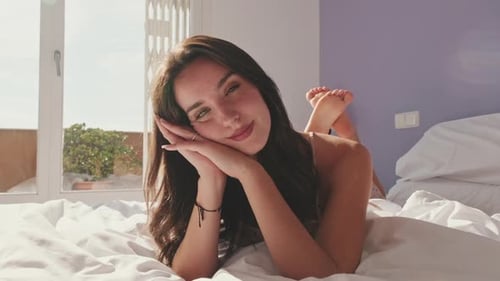 Close-up, happy girl posing lying in bed