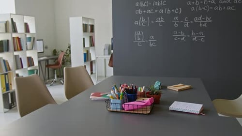 Classroom with chalkboard and school supplies on table