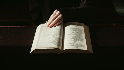 Sehen Sie sich ein heiteres Video von einer Person an, die die Bibel liest. Das Filmmaterial fängt den ruhigen Moment des Nachdenkens ein