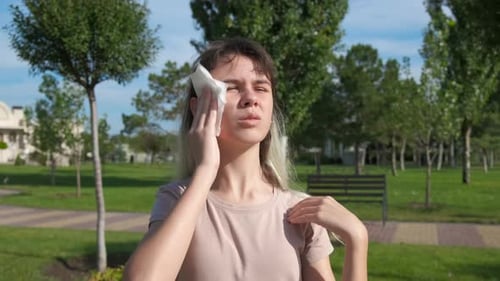 Young Woman Cooling Herself with Tissue on Hot Day
