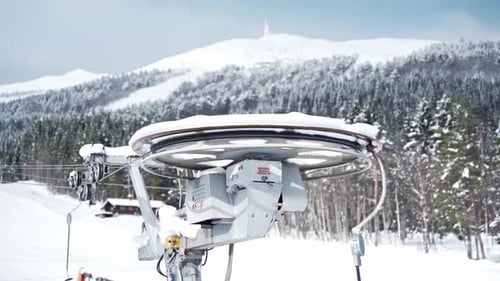 Ski lift rotating, beautiful pine forest and snow-covered mountain tops in the background. Norway.