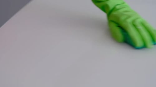 Slow Motion Close Up a Hand of Housewife in Green Rubber Glove Applying Cleansers to Rag and