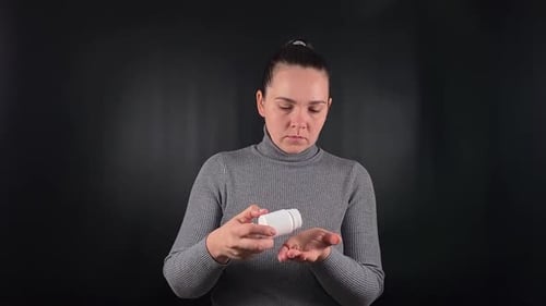 Woman Opens Pill Bottle, Takes Medication