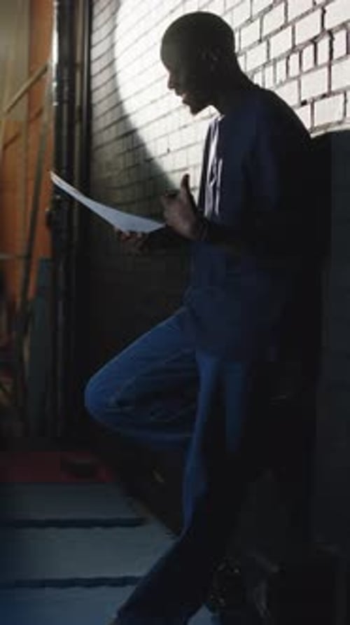 Man Reads Script in Dark Urban Alley