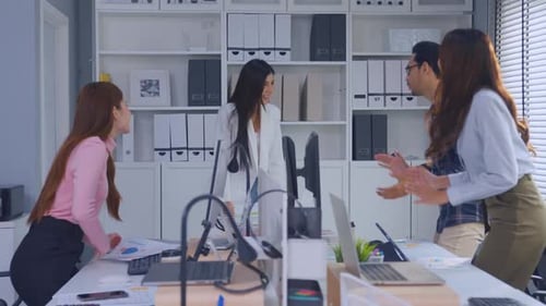 Enthusiastic Colleagues Celebrate Project Success in Office