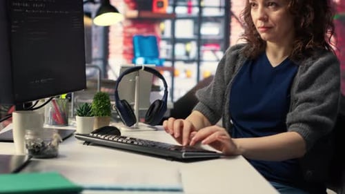 Desarrolladora de software en la oficina de la Agencia codificando en su computadora