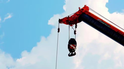 Industrial Crane Lifting Load Under Blue Sky