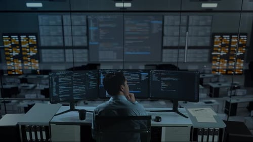 Asian Man Thinking About Something While Write Code With Multiple Computer Screens In office